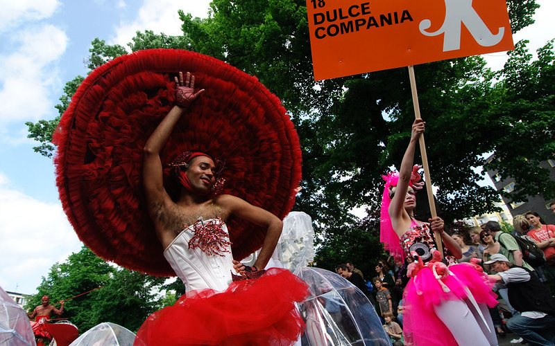 Woman in red outfit dancing at Karneval Der Kulturen festival in Germany.