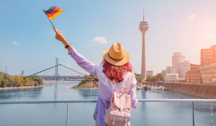 A young woman holding German flag in her hand