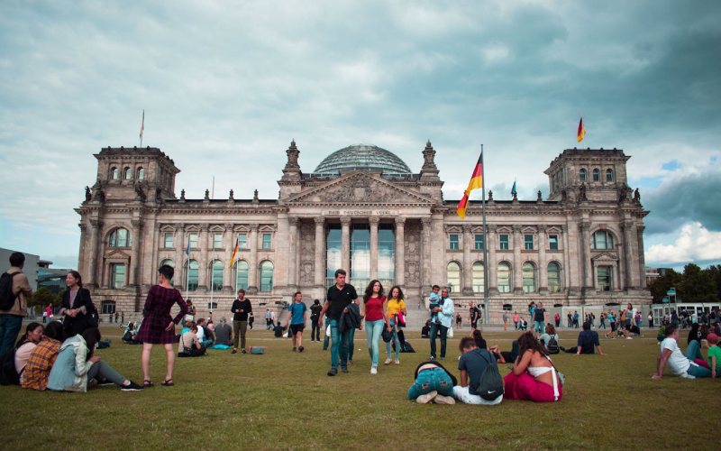 Boys and girls talking to each other under clear sky in Germany in Summer.